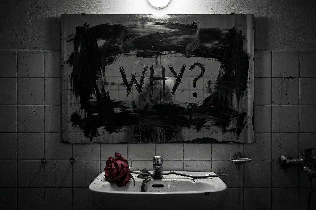 Representação da dor na música "Black": um espelho manchado de preto com a palavra "Why?" escrita, e uma rosa vermelha murcha.