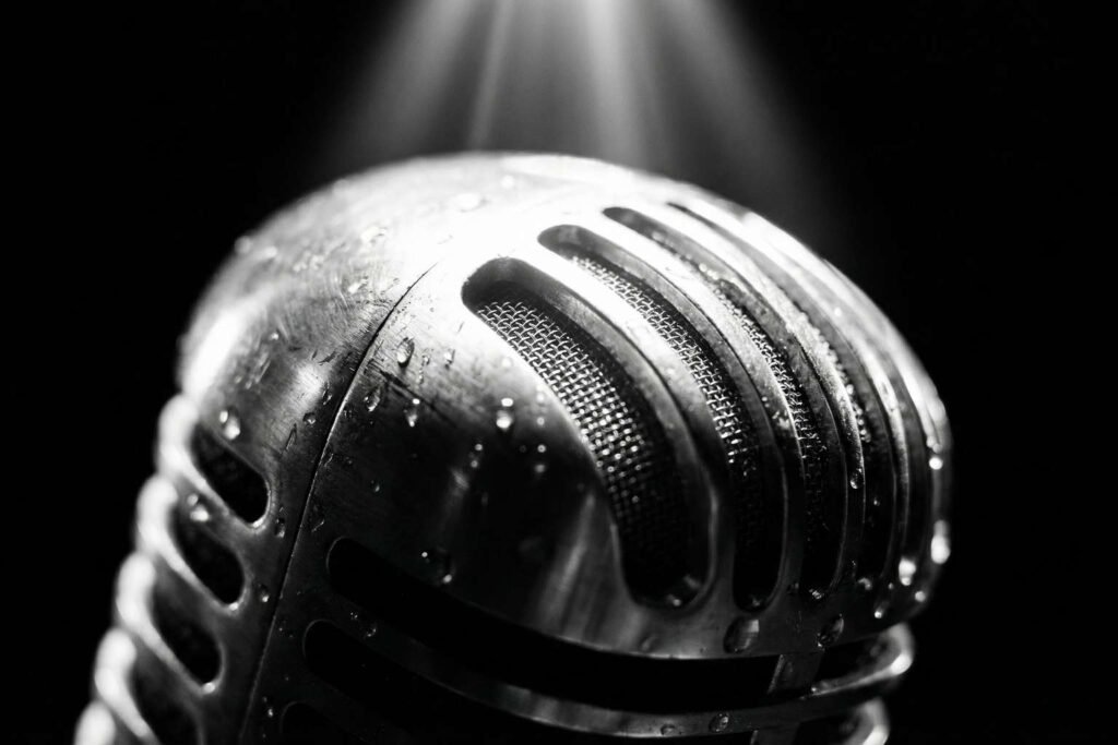 A catarse da performance de "Black" no MTV Unplugged, simbolizada por um microfone iluminado em um palco escuro.