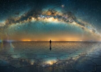 Ilustração cinematográfica de uma silhueta humana solitária observando um céu noturno vasto e repleto de estrelas e galáxias, representando o Paradoxo de Fermi.